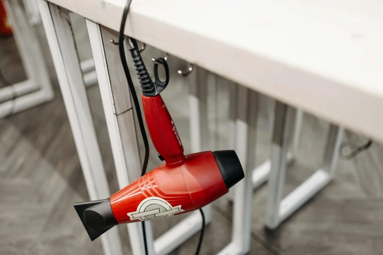 a red blow dryer sitting on top of a table, by Haukur Halldórsson, webdesign icon for solar carport, hair are wired cables, with a sleek spoiler, seattle