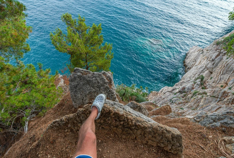 a person standing on top of a mountain next to the ocean, by Raphaël Collin, pexels contest winner, figuration libre, detailed shot legs-up, solo hiking in mountains trees, avatar image, costa blanca