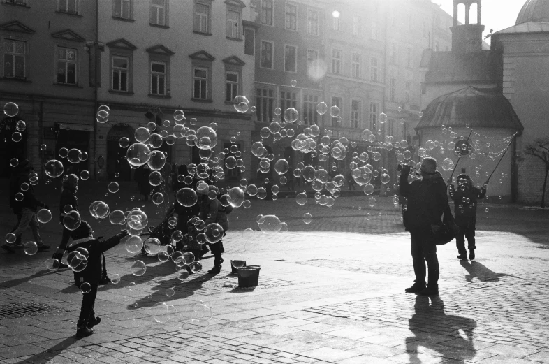 a black and white photo of people blowing bubbles, by Tobias Stimmer, pexels, in empty!!!! legnica, squares, sunlight glistening, medium format. soft light