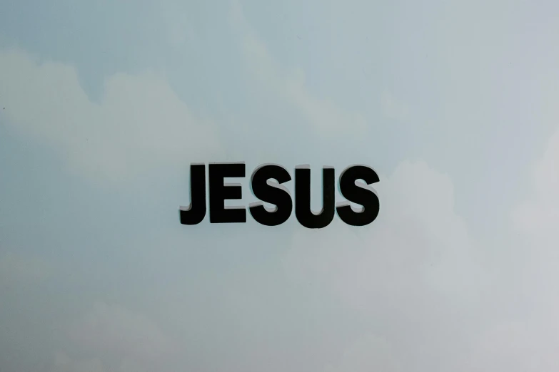 the word jesus written in black against a blue sky, an album cover, unsplash, on a gray background, television show, 3/4 view from below, insignia