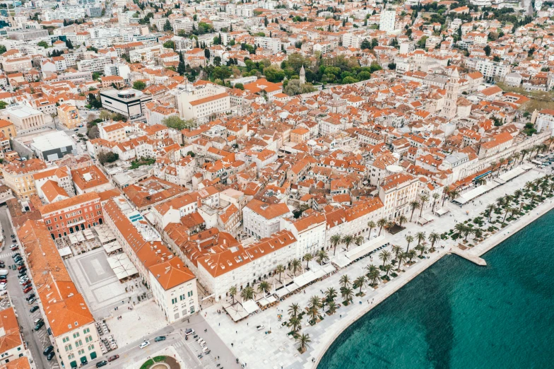 an aerial view of a city next to the ocean, by Emma Andijewska, pexels contest winner, baroque, square, split near the left, 🤬 🤮 💕 🎀, brown