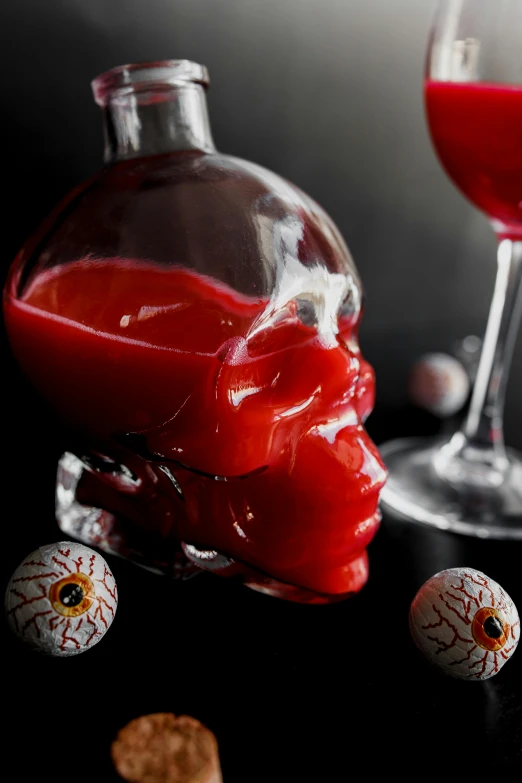 a bottle of red liquid sitting next to a glass of wine, inspired by François Bocion, vanitas, bloodshot eyeballs, sculpted out of candy, close up head shot, profile image