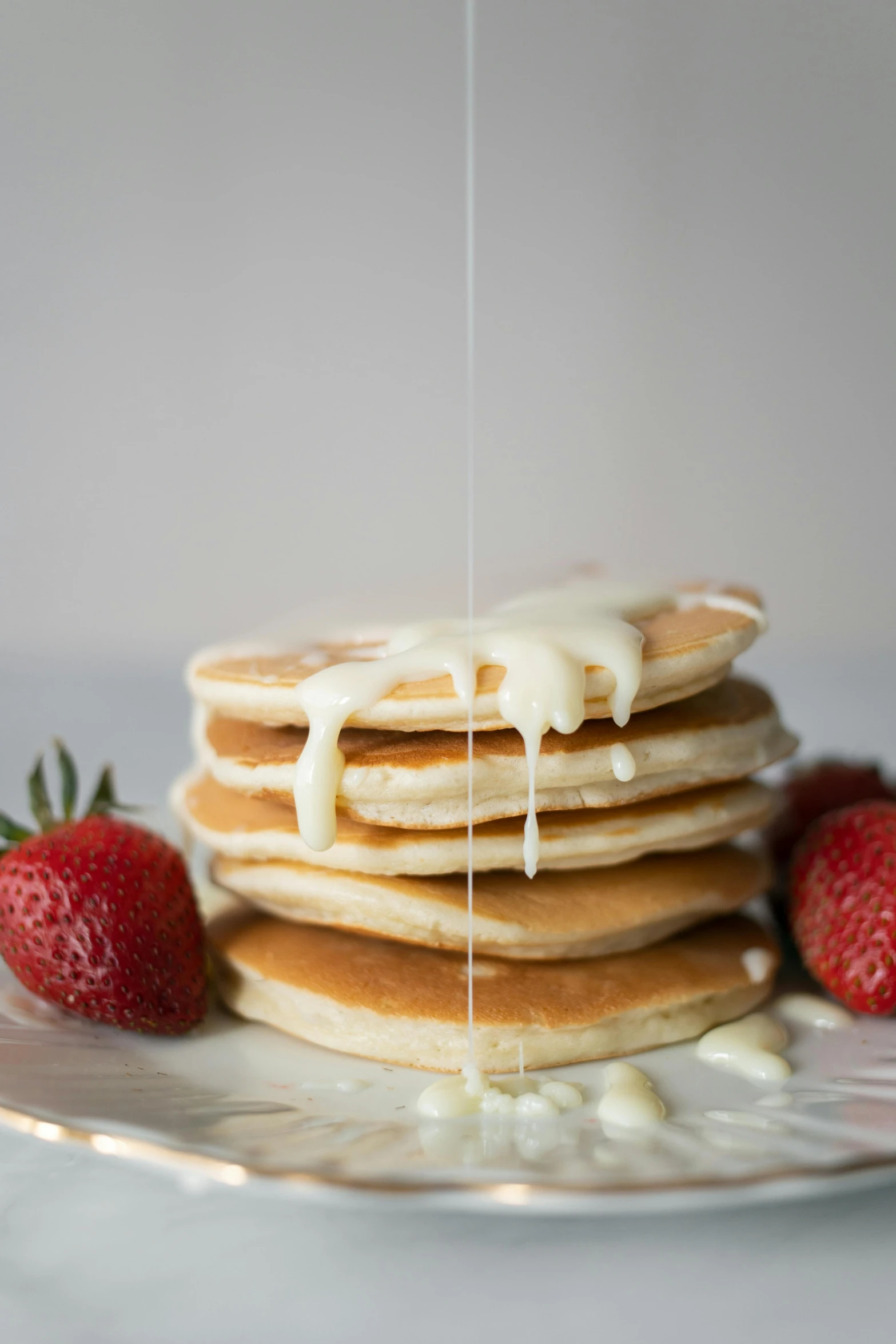 a stack of pancakes sitting on top of a white plate, unsplash, milk dripping, next to sliced strawberries, silver，ivory, 6 pack