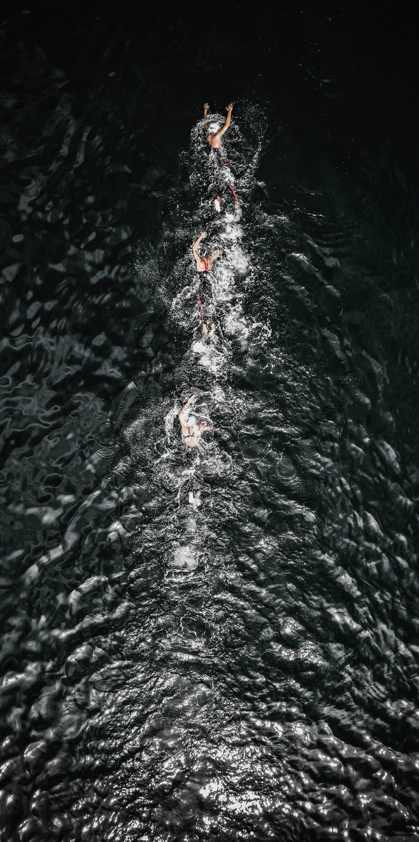 a couple of people that are in the water, inspired by Andreas Gursky, unsplash contest winner, on a black wall, drone footage, olympics, darkslategray wall