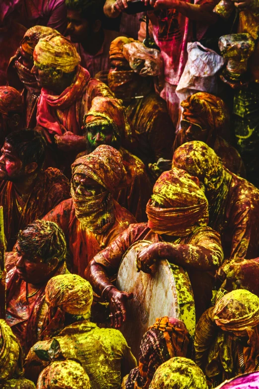 a crowd of people covered in green and red paint, inspired by Steve McCurry, pexels contest winner, color field, yellow robes, paisley, pigment textures, red ocher