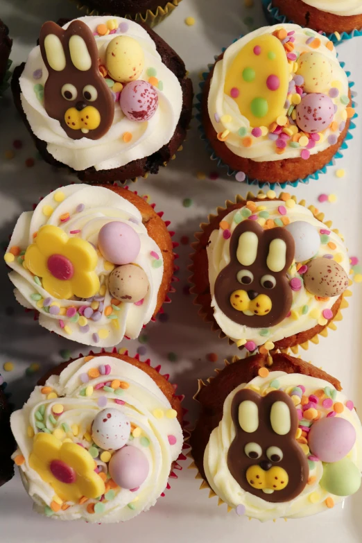 a white plate topped with cupcakes covered in frosting, a cartoon, pexels, easter, 3 / 4 photographic close, paisley, thumbnail