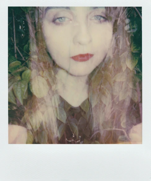 a close up of a person with long hair, a polaroid photo, inspired by Elsa Bleda, renaissance, poison ivy, imogen poots, pale skin and purple eyes, slightly red