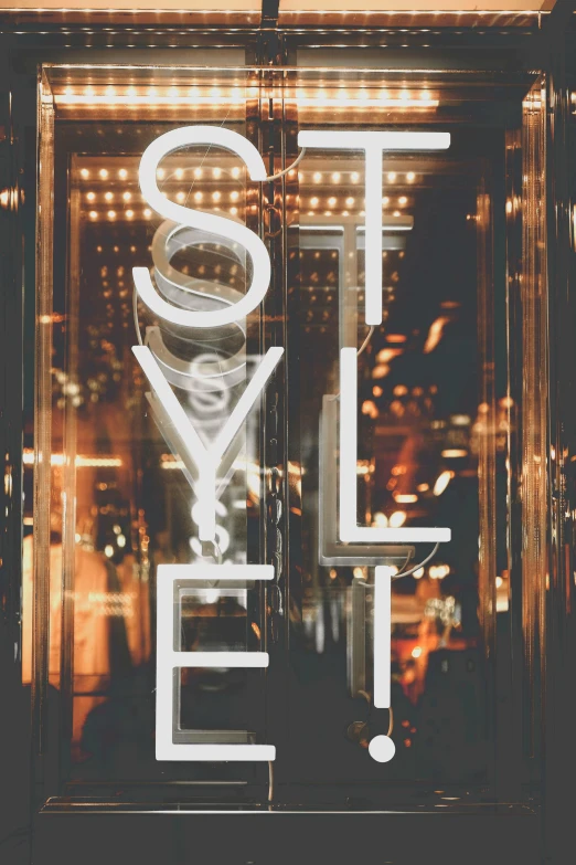 a sign that is on the side of a building, by Zack Stella, trending on unsplash, international typographic style, reflecting light in a nightclub, : 5 stylish, fashion magazine style, stage lighrt