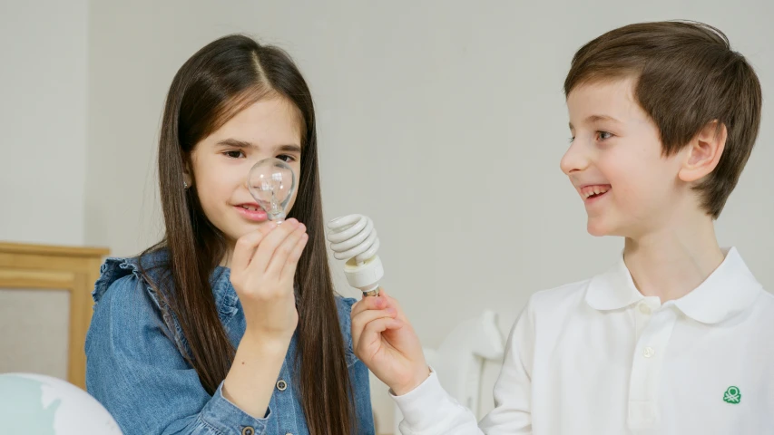 a couple of kids standing next to each other, pexels contest winner, fantastic realism, edison bulb, dentist, vocal tract model, holding electricity