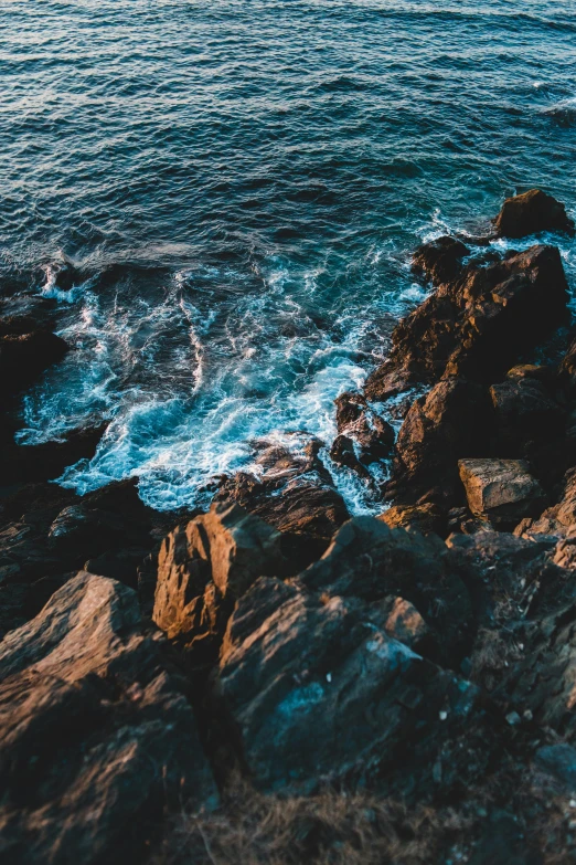 a large body of water next to a rocky shore, pexels contest winner, happening, gnarly details soft light, a high angle shot, multiple stories, intense emotion