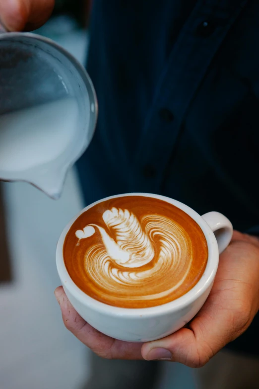 a close up of a person holding a cup of coffee, swirls, aussie baristas, moonlit, pouring techniques