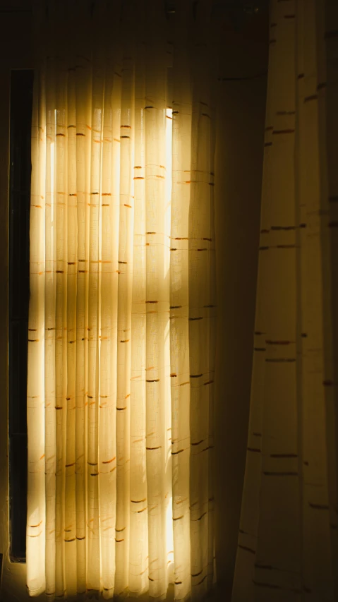 a light shines through a window in a dark room, an album cover, inspired by Elsa Bleda, unsplash, curtains, golden hour closeup photo, yellowish light, hotel room