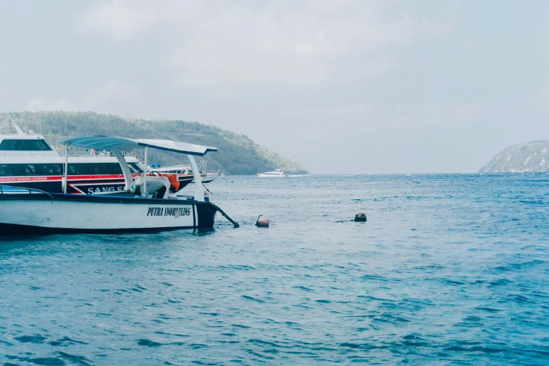 a boat that is sitting in the water, by Carey Morris, pexels contest winner, sumatraism, scuba diving, banner, grey, 🦩🪐🐞👩🏻🦳