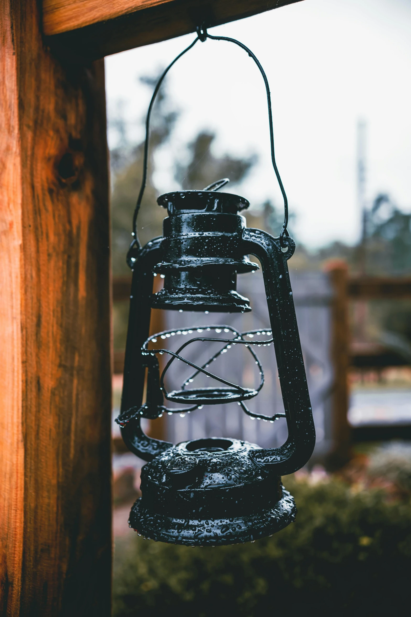 a black lantern hanging from a wooden pole, pexels contest winner, detailed moisture, rusting, instagram post, hyperdetailed