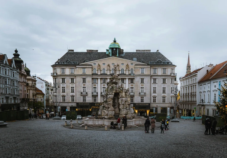 a large building with a fountain in the middle of it, a statue, by Tobias Stimmer, unsplash contest winner, baroque winding cobbled streets, square, olafur eliasson, streetscapes