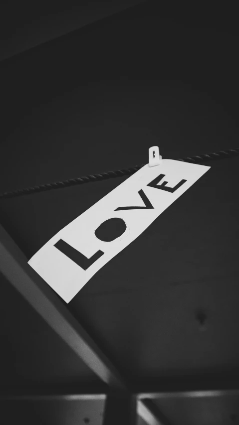 a black and white photo of a love sign, a black and white photo, label, lapel, reflective material, laundry hanging