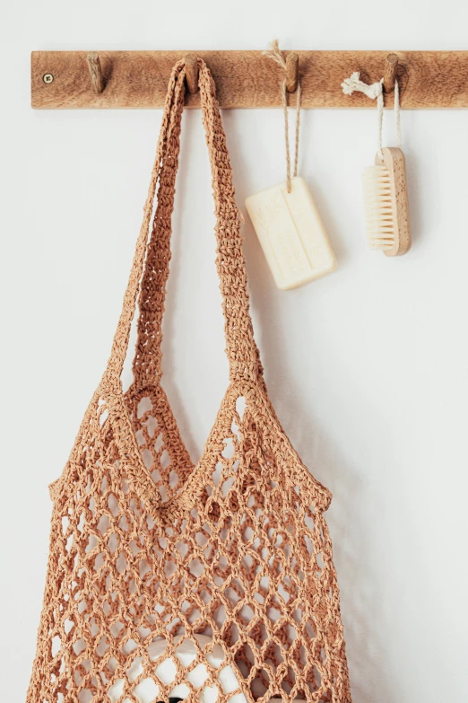 a crocheted bag hanging on a wall, unsplash, soap, sustainable materials, bralette, getting groceries