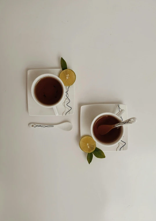 a couple of cups of tea sitting on top of a white table, inspired by Wlodzimierz Tetmajer, reddit, square, detailed product image, spoon placed, organic lines