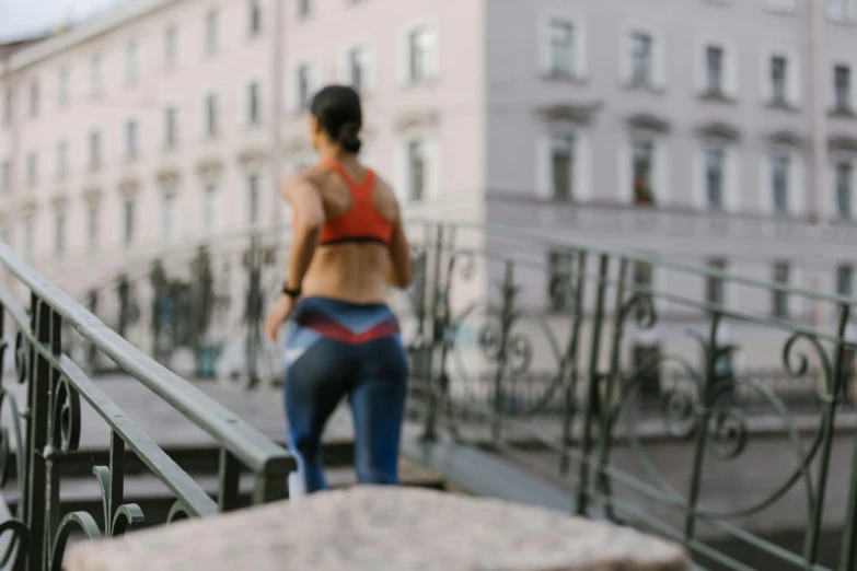 a woman walking down a set of stairs, pexels contest winner, happening, athletic muscle tone, kreuzberg, background image, bridge