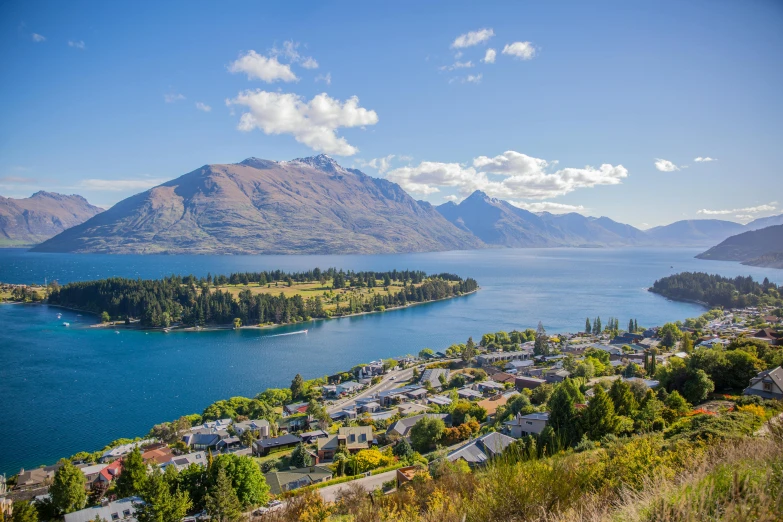 a view of the lake and mountains from the top of a hill, by Peter Churcher, pexels contest winner, hurufiyya, new zealand, avatar image, beautiful small town, sunny day time