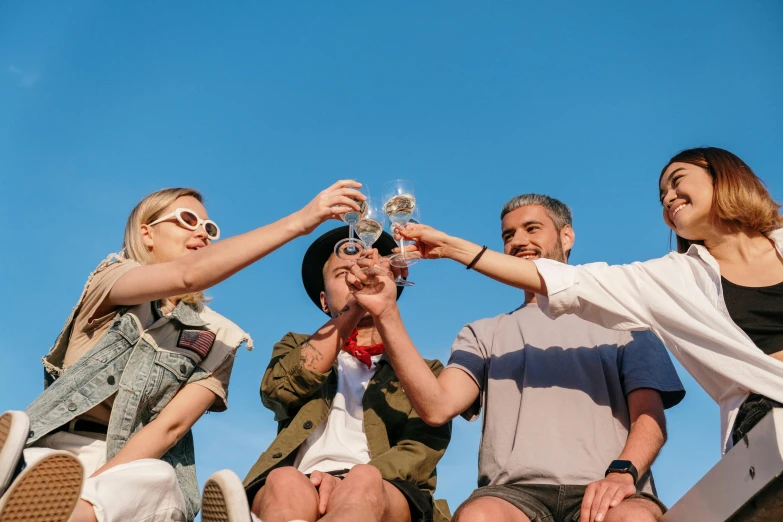 a group of people sitting on top of a roof, pexels contest winner, holding glass of wine, clear blue skies, avatar image, revellers