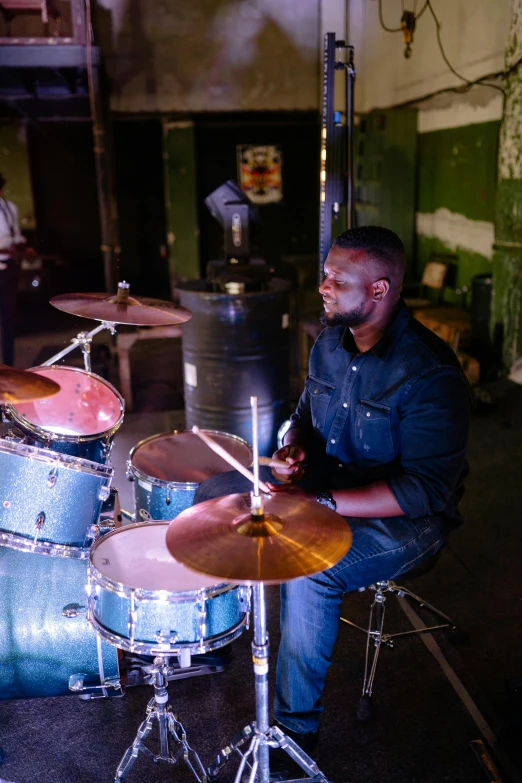 a man sitting in front of a drum set, profile image