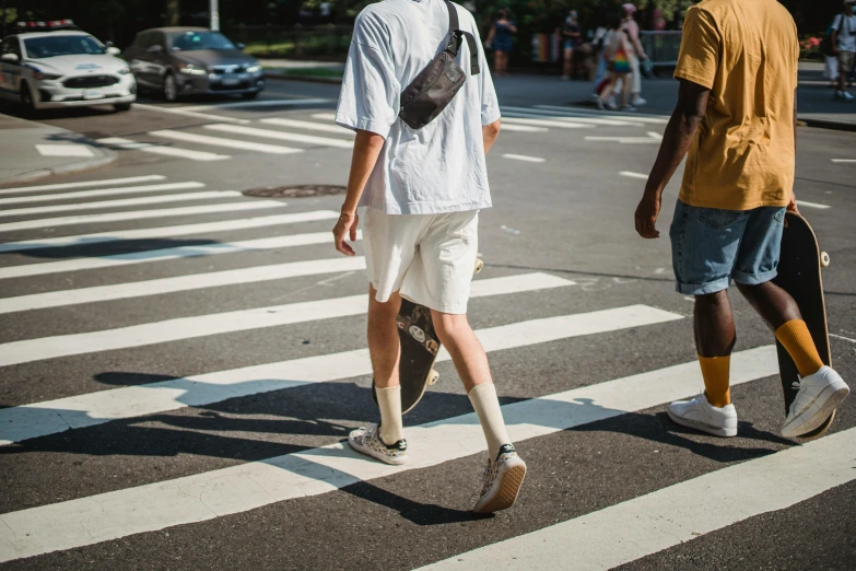 a man walking across a crosswalk with a skateboard, trending on unsplash, renaissance, tan skin a tee shirt and shorts, wearing white clothes, ignant, people at work