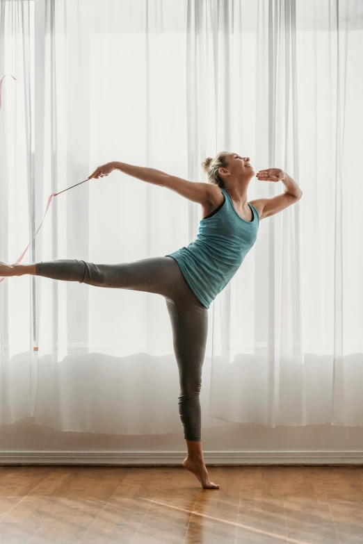 a woman doing a yoga pose in front of a window, arabesque, wielding a bow, promo image, ribbon, concern