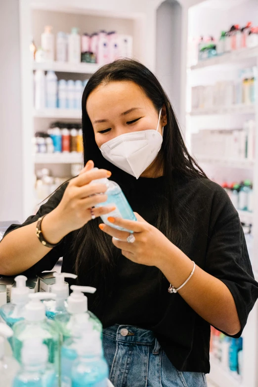 a woman wearing a face mask in a pharmacy, pexels contest winner, process art, holding a bottle, silicone skin, jen yoon, designer product