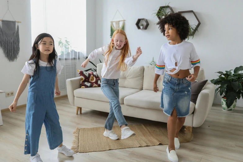 a group of young girls standing next to each other in a living room, by Elaine Hamilton, pexels contest winner, interactive art, he is dancing, wearing jeans, diverse ages, performing a music video