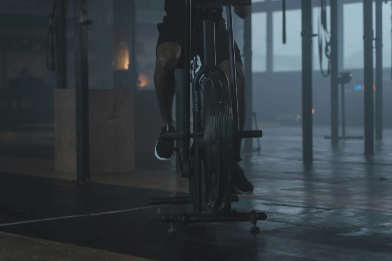 a man riding a bike in a gym, pexels contest winner, realism, cinematic establishing shot, background image, hammershøi, lower body