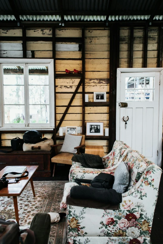 a person laying on a couch in a living room, by Peter Churcher, unsplash, wooden cottage, lined in cotton, old chairs, manuka