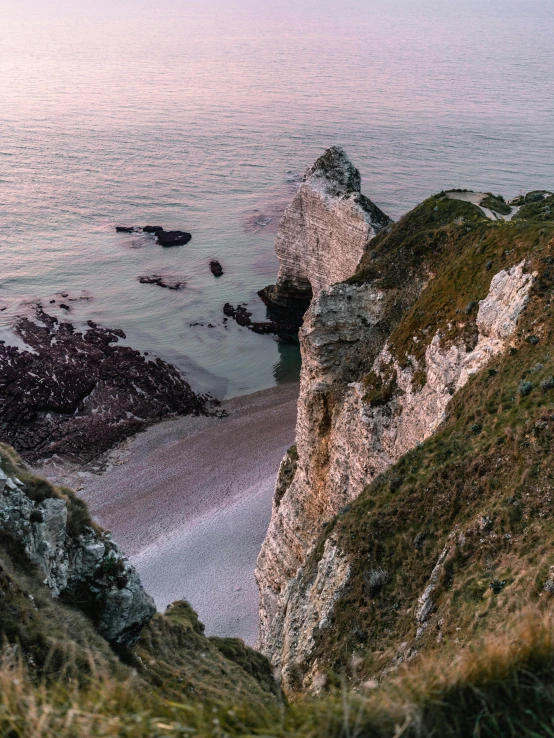 a view of a beach from the top of a hill, by Daniel Seghers, pexels contest winner, chalk cliffs above, cliff side at dusk, high quality photo, chiseled formations