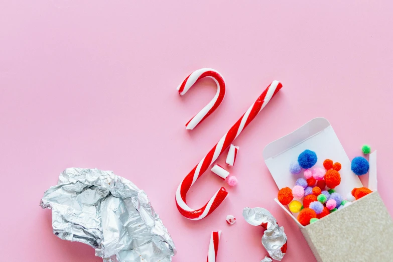 candy canes, pom poms, and candy canes on a pink background, trending on pexels, foil, letter s, background image, thumbnail