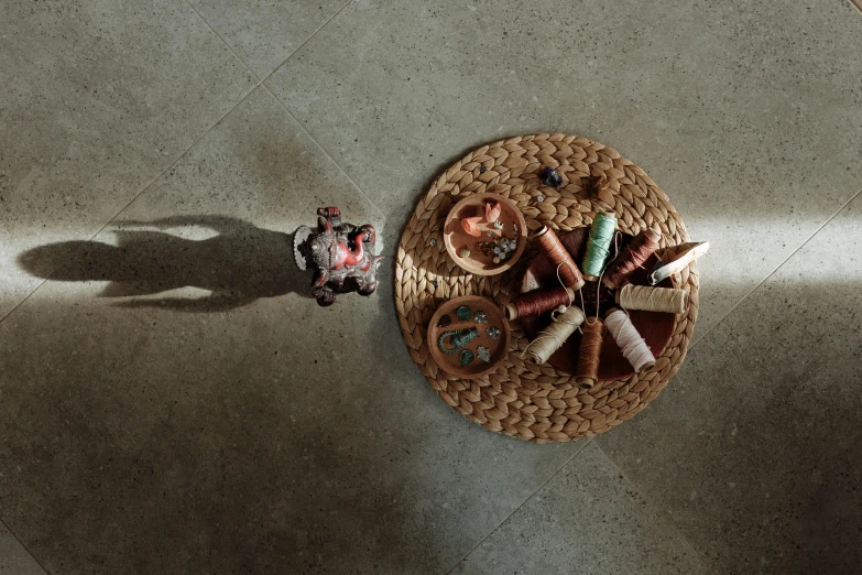 a basket filled with assorted items sitting on top of a floor, inspired by Andy Goldsworthy, pexels contest winner, fairy circle, shadow play, moroccan tea set, studio shot