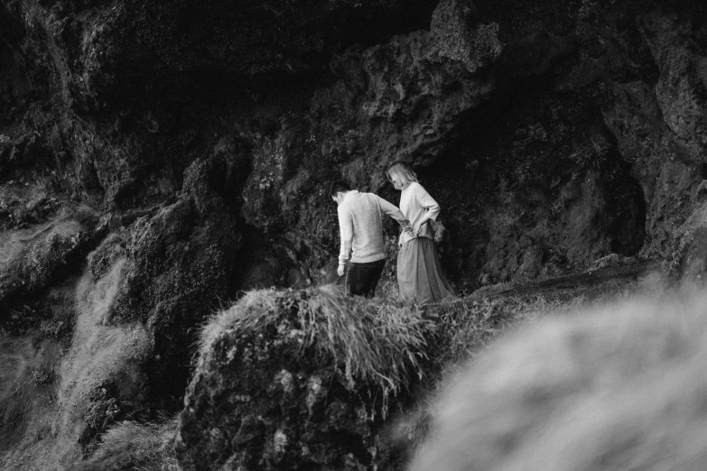 a man and woman standing on top of a cliff, a black and white photo, unsplash, romanticism, black sand, medium format. soft light, 15081959 21121991 01012000 4k, digging