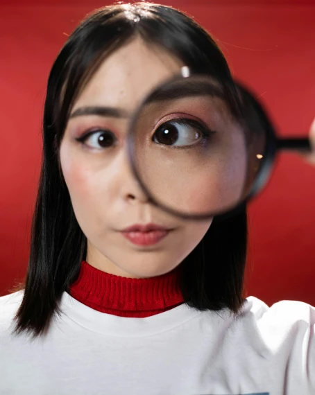 a woman looking through a magnifying glass, inspired by Yanjun Cheng, trending on pexels, hyperrealism, googly eyes, red filter, gif, asian face