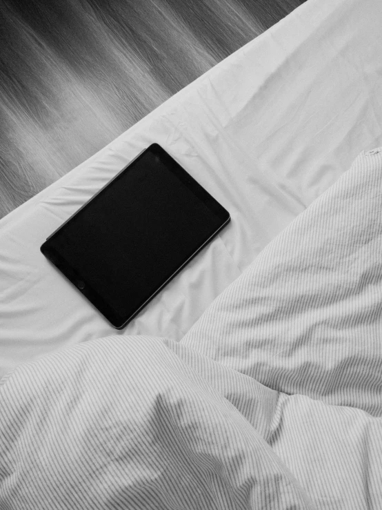 a tablet computer sitting on top of a bed, by Adam Rex, lena oxton, blank