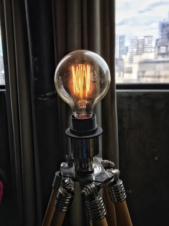 a light bulb sitting on top of a tripod, inspired by George Fiddes Watt, interior light, small nixie tubes, rembrandt lighting, medium close up shot