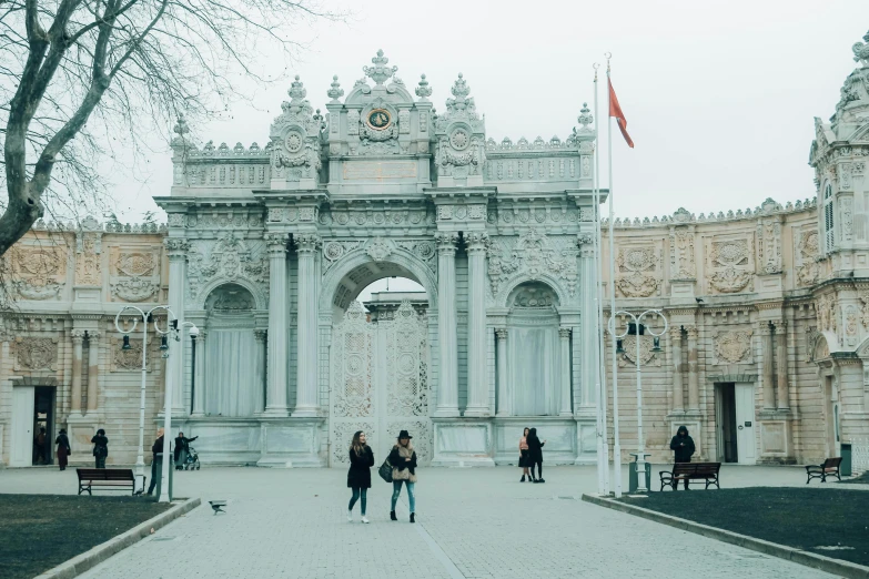 a couple of people that are standing in front of a building, a marble sculpture, by Niyazi Selimoglu, pexels contest winner, art nouveau, torri gate, square, turkish and russian, a palace with a thousand long