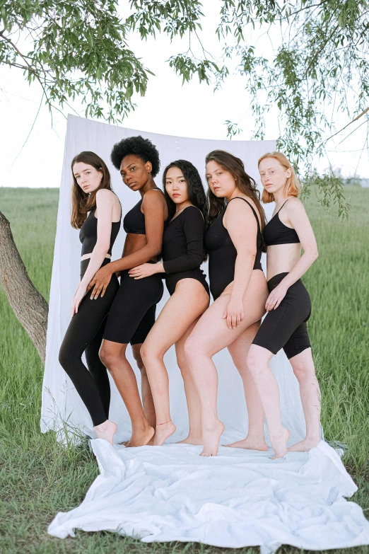 a group of women standing next to each other, inspired by Vanessa Beecroft, unsplash, tight black tank top and shorts, photoshoot for skincare brand, character is in her natural pose, various colors