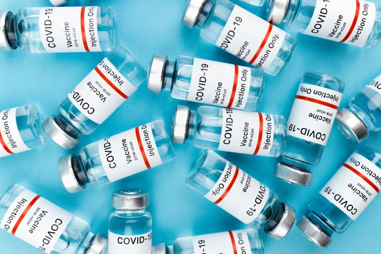 a bunch of vials sitting on top of a blue surface, medical labels, instagram post, covid, gray