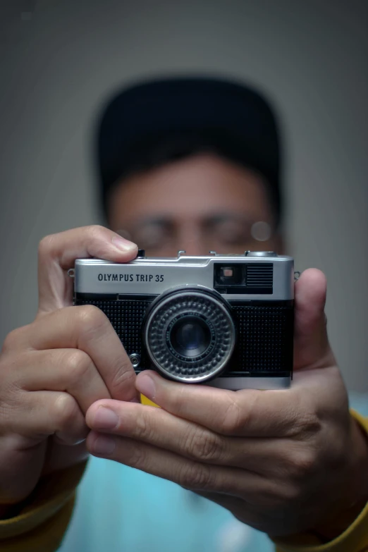 a man taking a picture with a camera, inspired by Rudy Siswanto, olympus, upper body face shot, photographed for reuters, colored photo