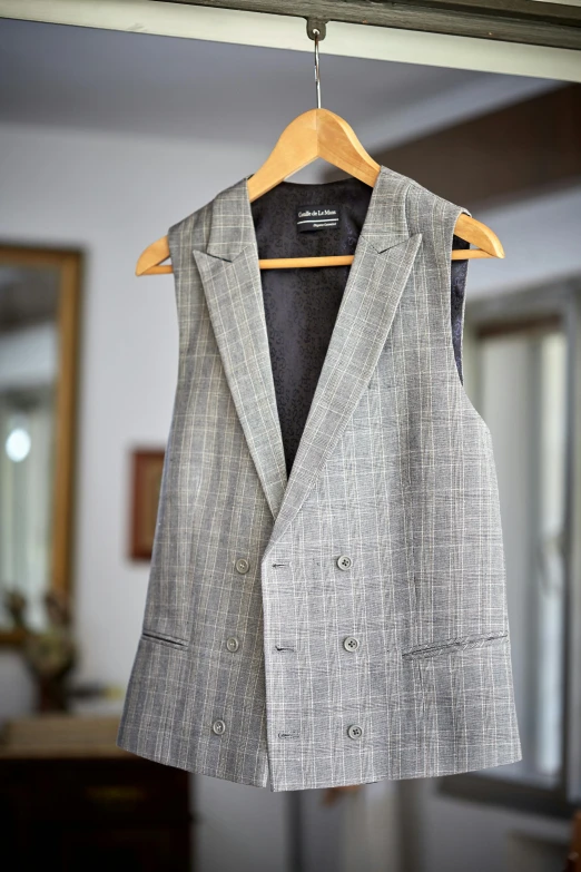 a suit hanging on a hanger in a room, a portrait, inspired by Constantine Andreou, unsplash, wearing a vest top, tartan garment, grey robes, ready for a meeting