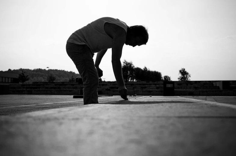 a black and white photo of a person on a skateboard, by Jan Rustem, concrete art, doing a prayer, working hard, taken at golden hour, carpenter