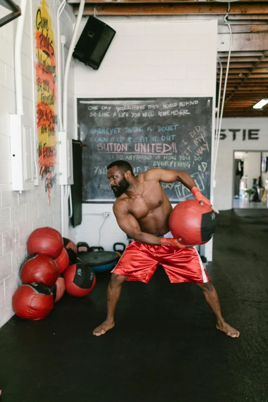 a man with boxing gloves in a gym, an album cover, by Jessie Alexandra Dick, pexels contest winner, happening, athletic body build, holding a ball, mkbhd as iron man, open belly