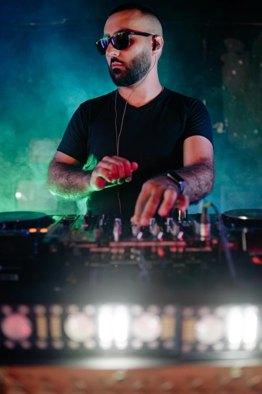 a man that is standing in front of a dj, trending on pexels, reza afshar, serious composure, party, 15081959 21121991 01012000 4k