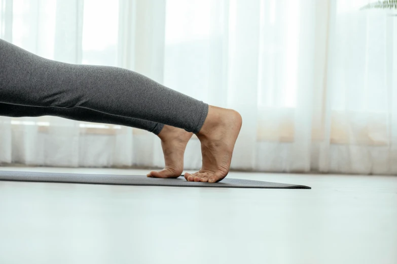 a woman doing a yoga pose on a yoga mat, by Victorine Foot, trending on pexels, arabesque, normal legs, manuka, visible veins, balance beams