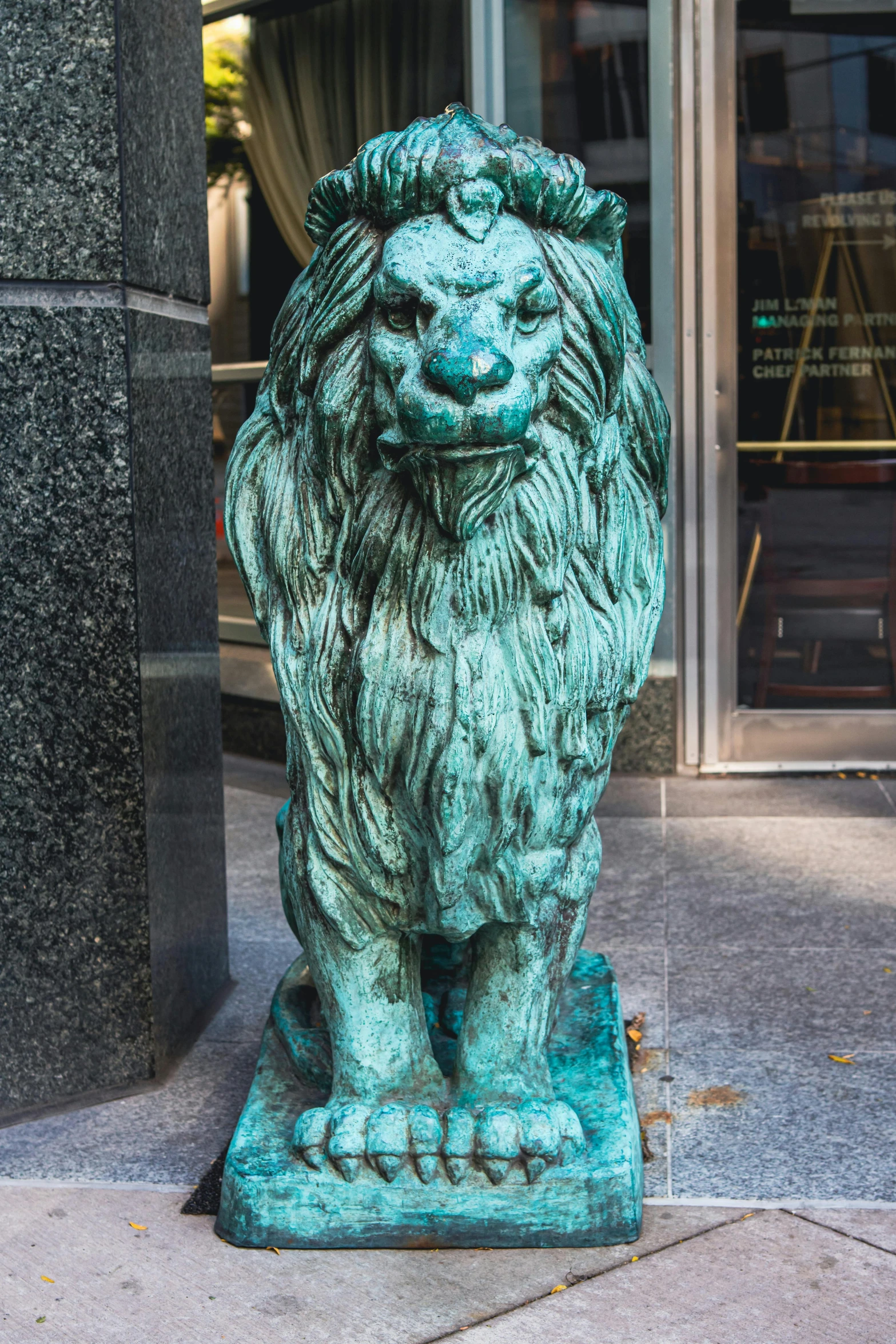 a statue of a lion in front of a building, street of teal stone, chicago, bronze, doran