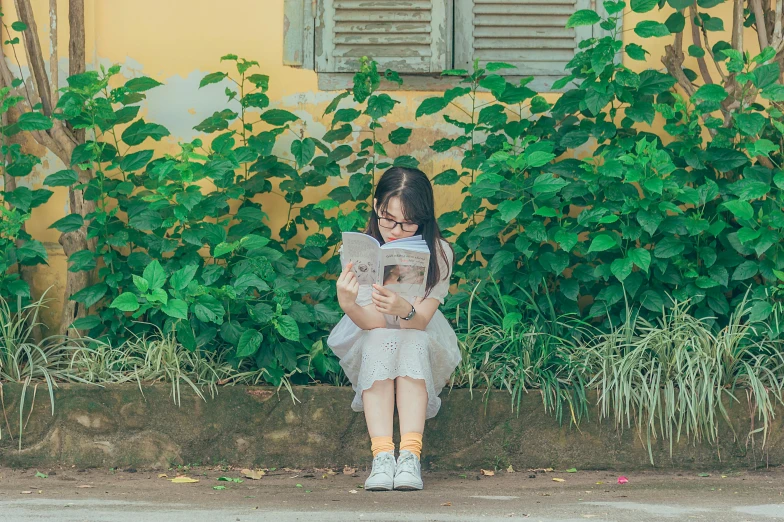 a little girl sitting on a bench reading a newspaper, pexels contest winner, realism, an overgrown library, a young asian woman, yellow hue, belle delphine